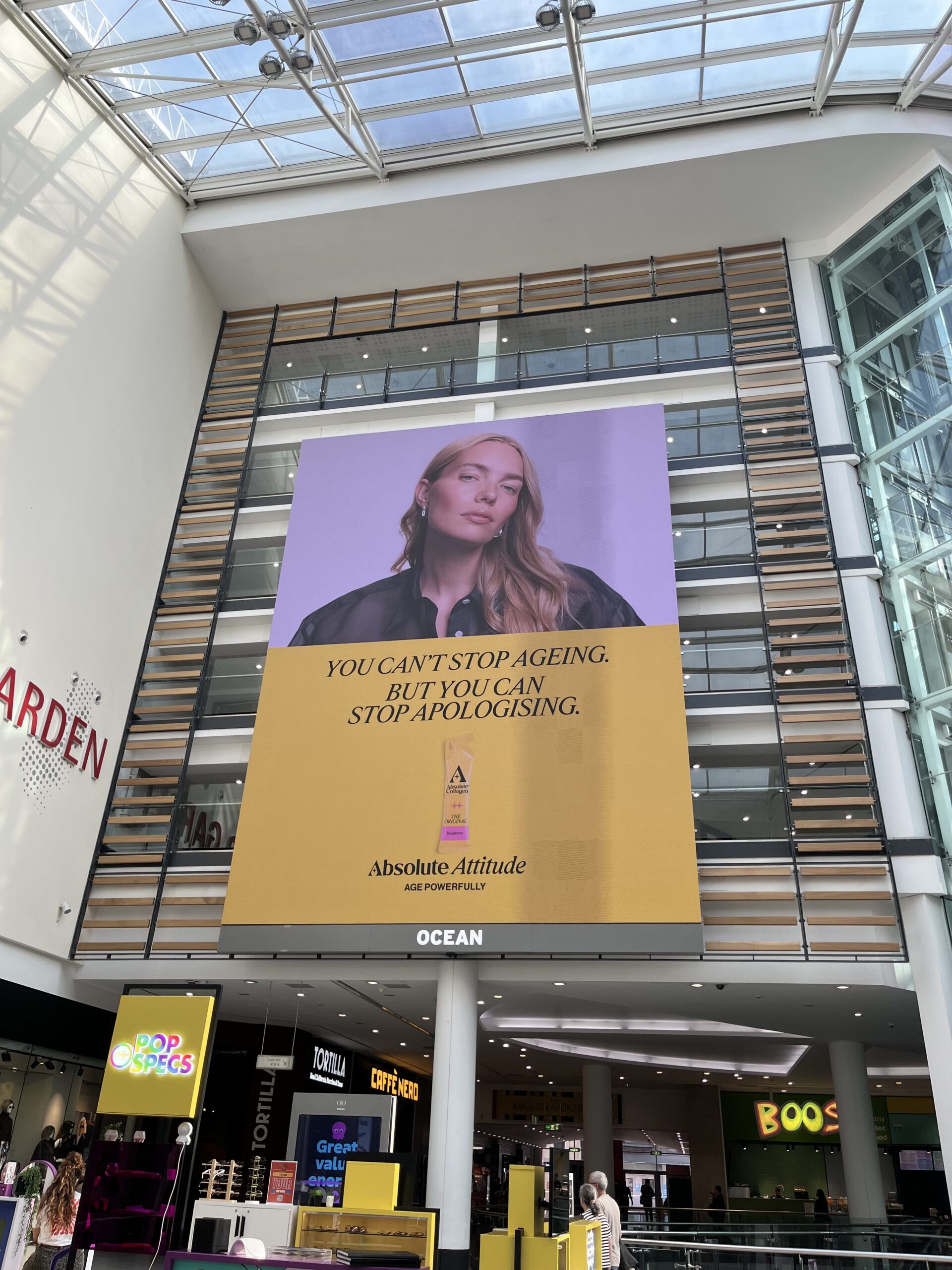 Absolute Collagen You can't stop ageing but you can stop apologising campaign on an indoor screen