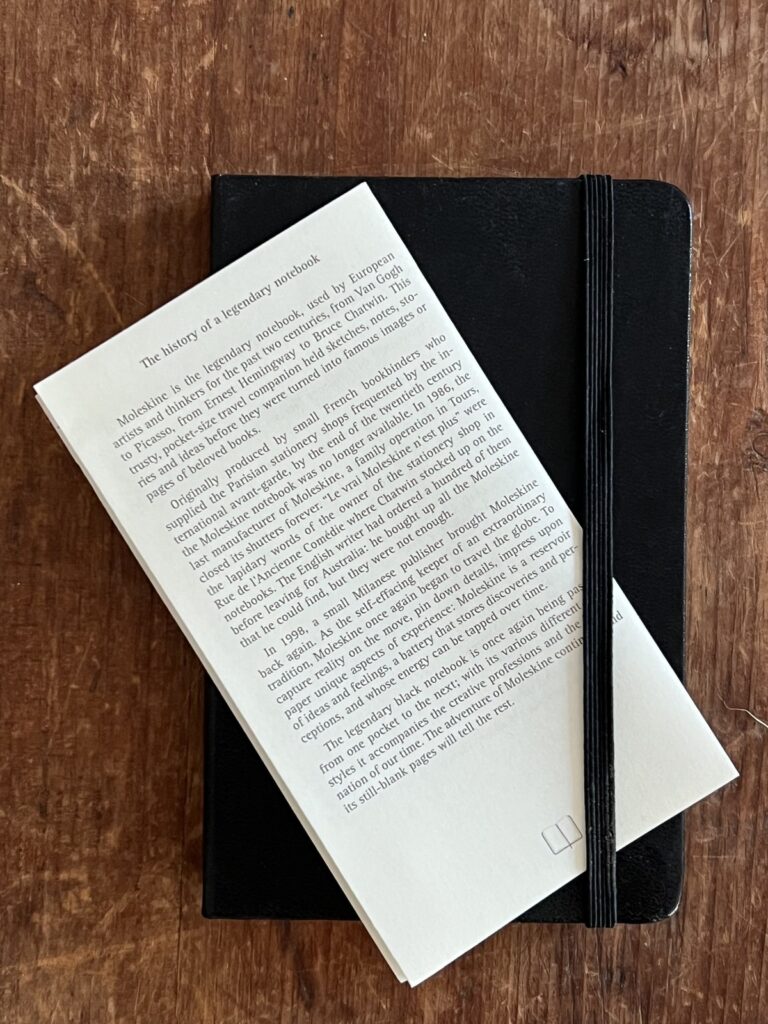 Moleskine notebook with a leaflet telling the brand’s story